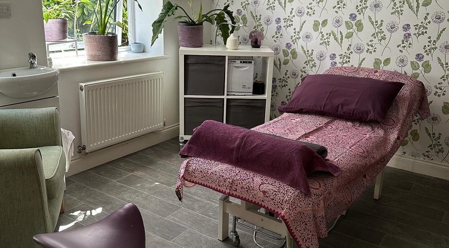 Relaxing treatment room at Kaye Booth Reflexology, Ripley, England, GB with floral decor and therapy bed.