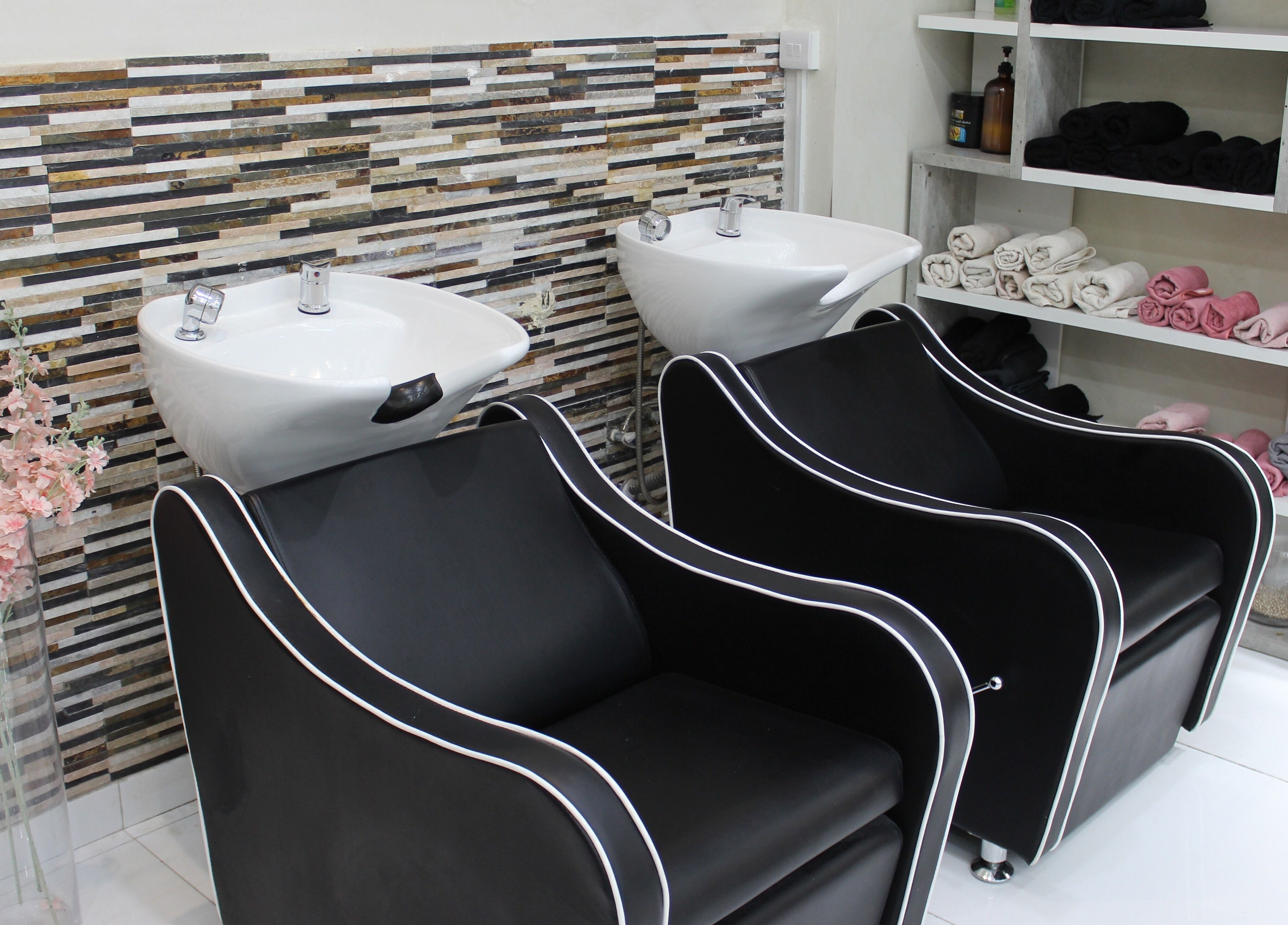 Elegant wash stations at Pink Line Beauty Salon, دبي, دبي, AE, featuring modern black chairs and stylish decor.