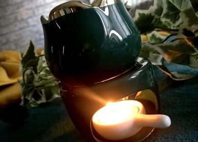 A serene candle light at Emerald Touch Massage, York, England, GB creating a calming ambiance with leafy decor.