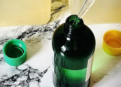 A green bottle with pipette at Emerald Touch Massage, York, England, GB, used for soothing wellness treatments.