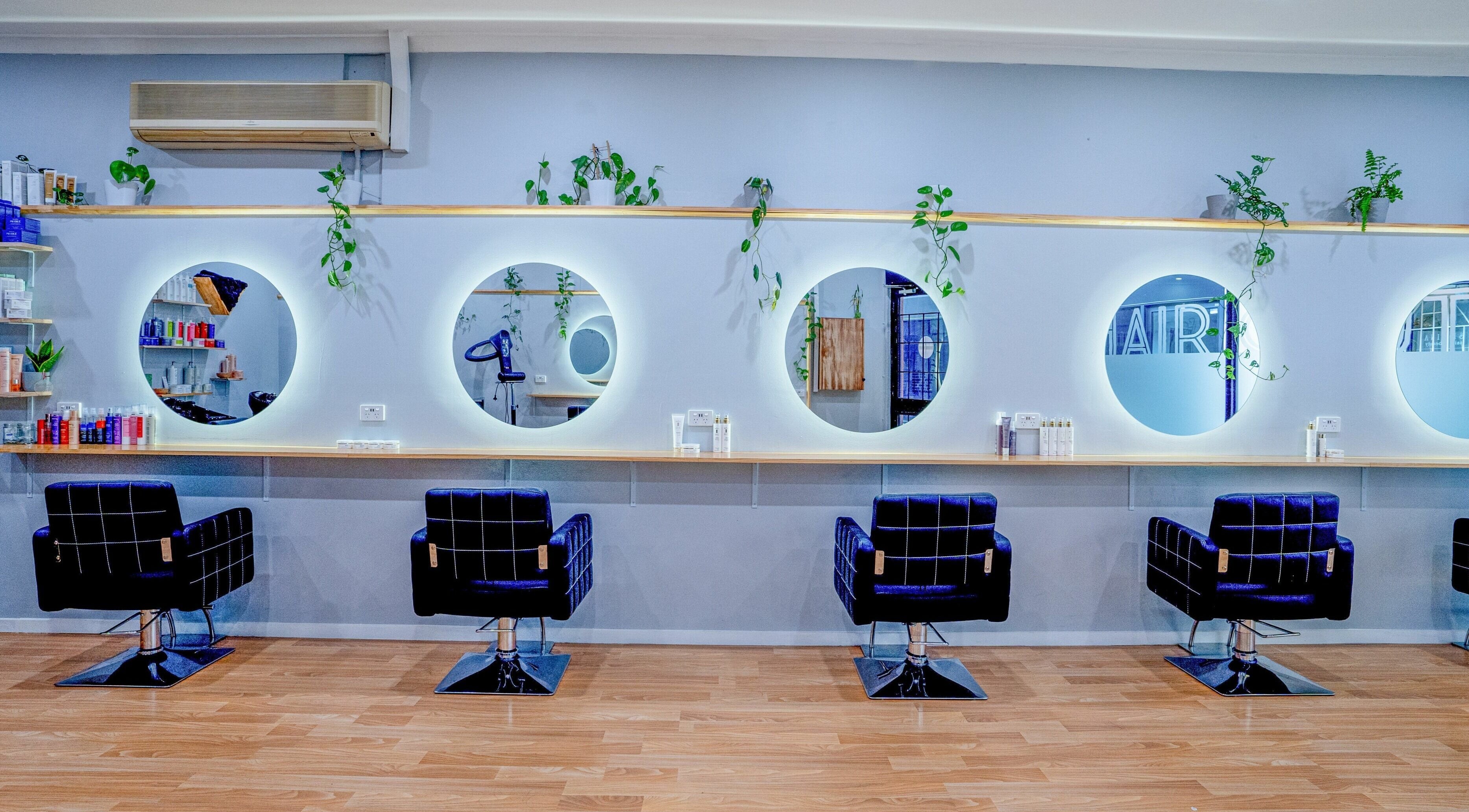 Chic salon interior at Bel Hair Couture in Melbourne, Victoria, AU featuring stylish chairs and sleek mirrors.
