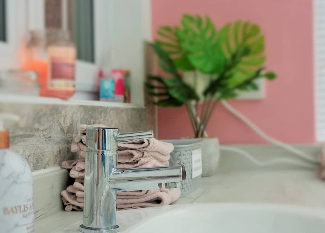 Elegant sink area at Pro Radiance, Havant, England, GB, featuring lush plants and soft towels.