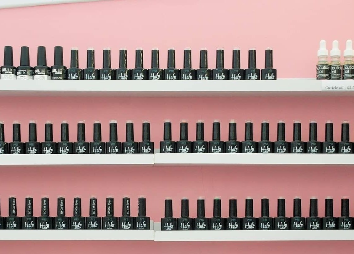 Colorful nail polish display at Pro Radiance, Havant, England, GB on a pink wall.