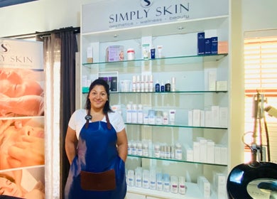 Staff member at Simply Skin Aesthetics, Wellness and Beauty in Cape Town, Western Cape, ZA, with elegant product display.