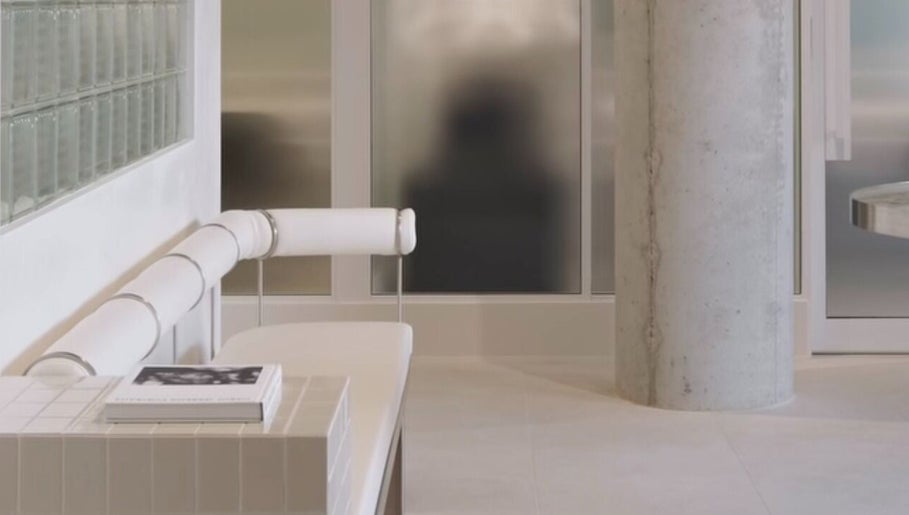 Sleek interior of SJ Hair Collective in Innaloo, Western Australia, AU, featuring modern white seating and decor.
