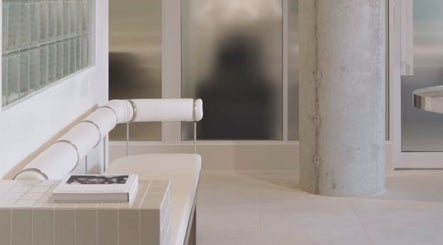 Sleek interior of SJ Hair Collective in Innaloo, Western Australia, AU, featuring modern white seating and decor.