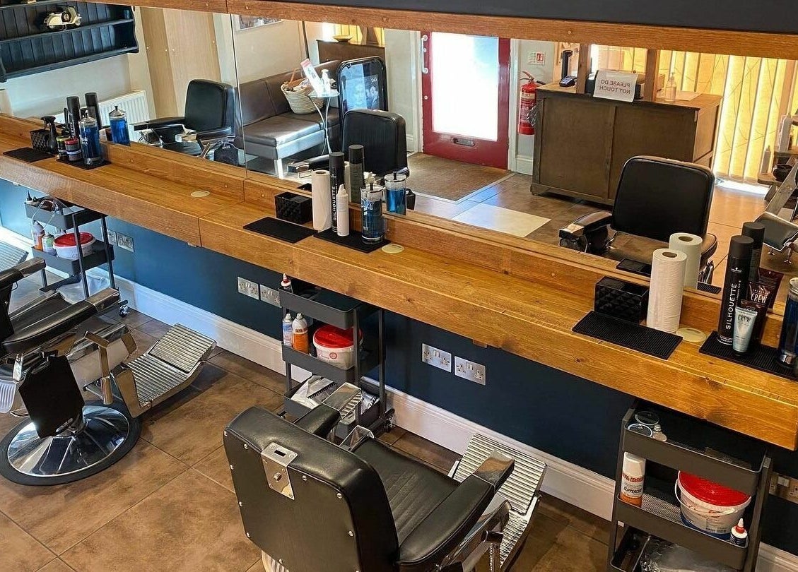 Stylish barber chairs and wooden counter at Clippers for Men in Southam, England, GB.