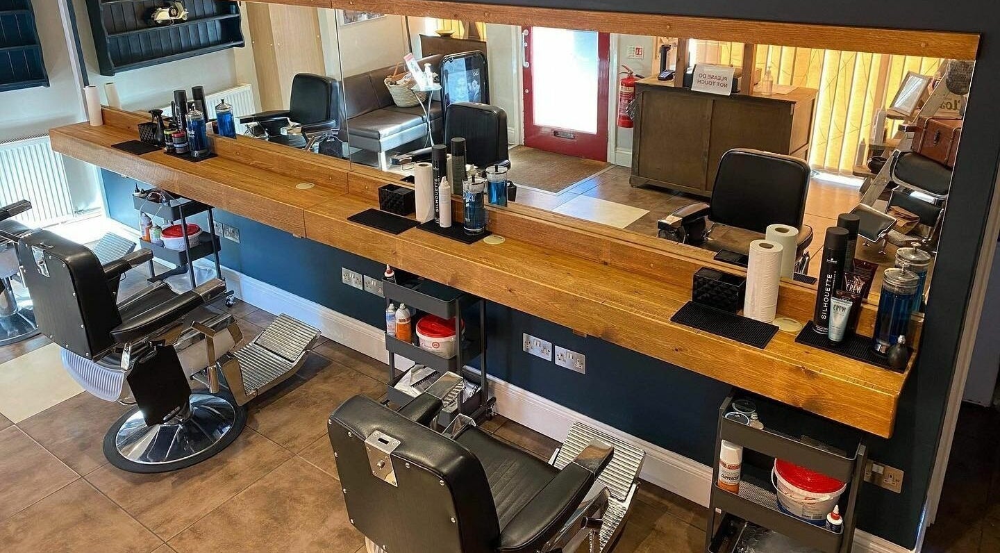 Stylish barber chairs and wooden counter at Clippers for Men in Southam, England, GB.