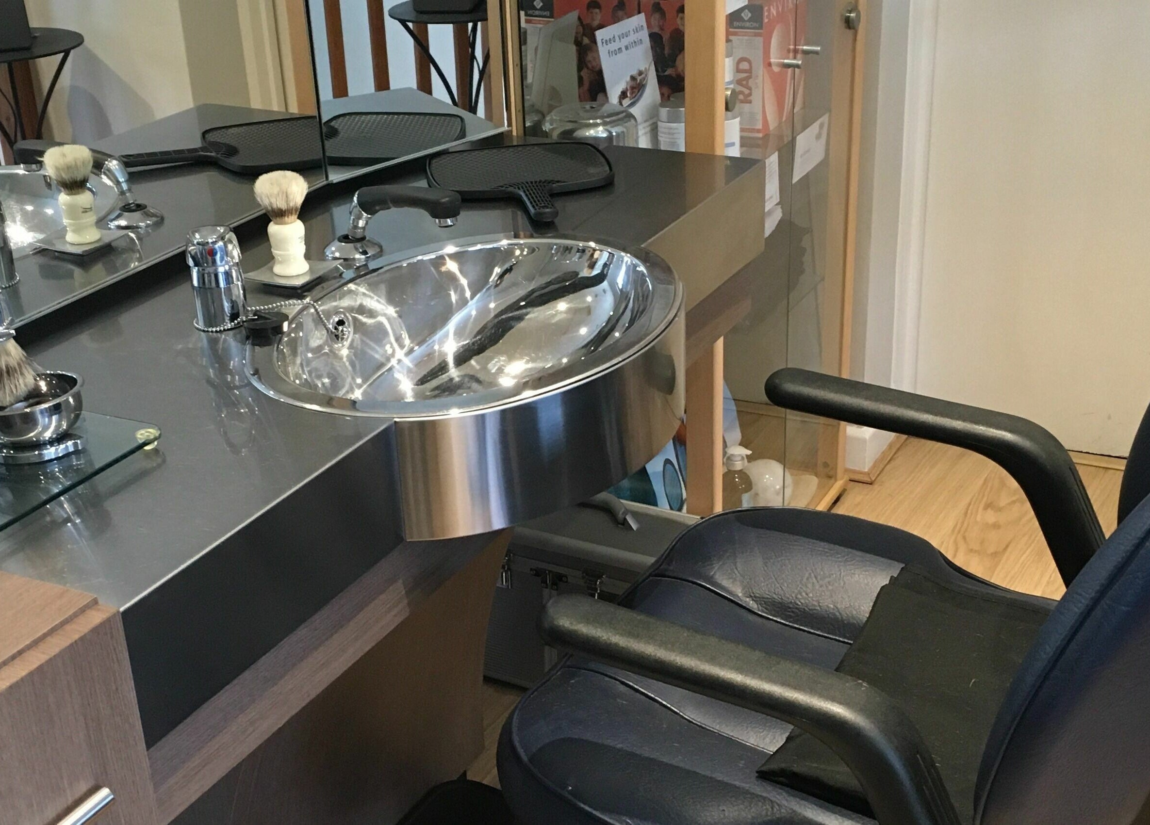 Sleek barber chair and grooming station at Clippers for Men in Southam, England, GB.