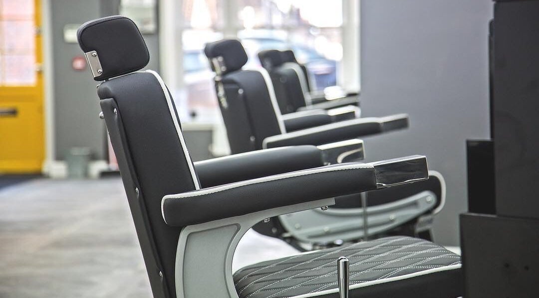 Modern barber chairs at Sean Beck & Sides, Stoke-on-Trent, England, GB showcasing sleek design.