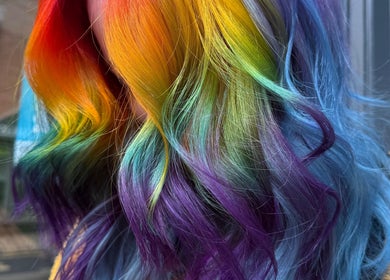 Vibrant rainbow hair color at Lauren Wingfield at Heartbreakers, Exeter, England, GB showcasing creative styling.