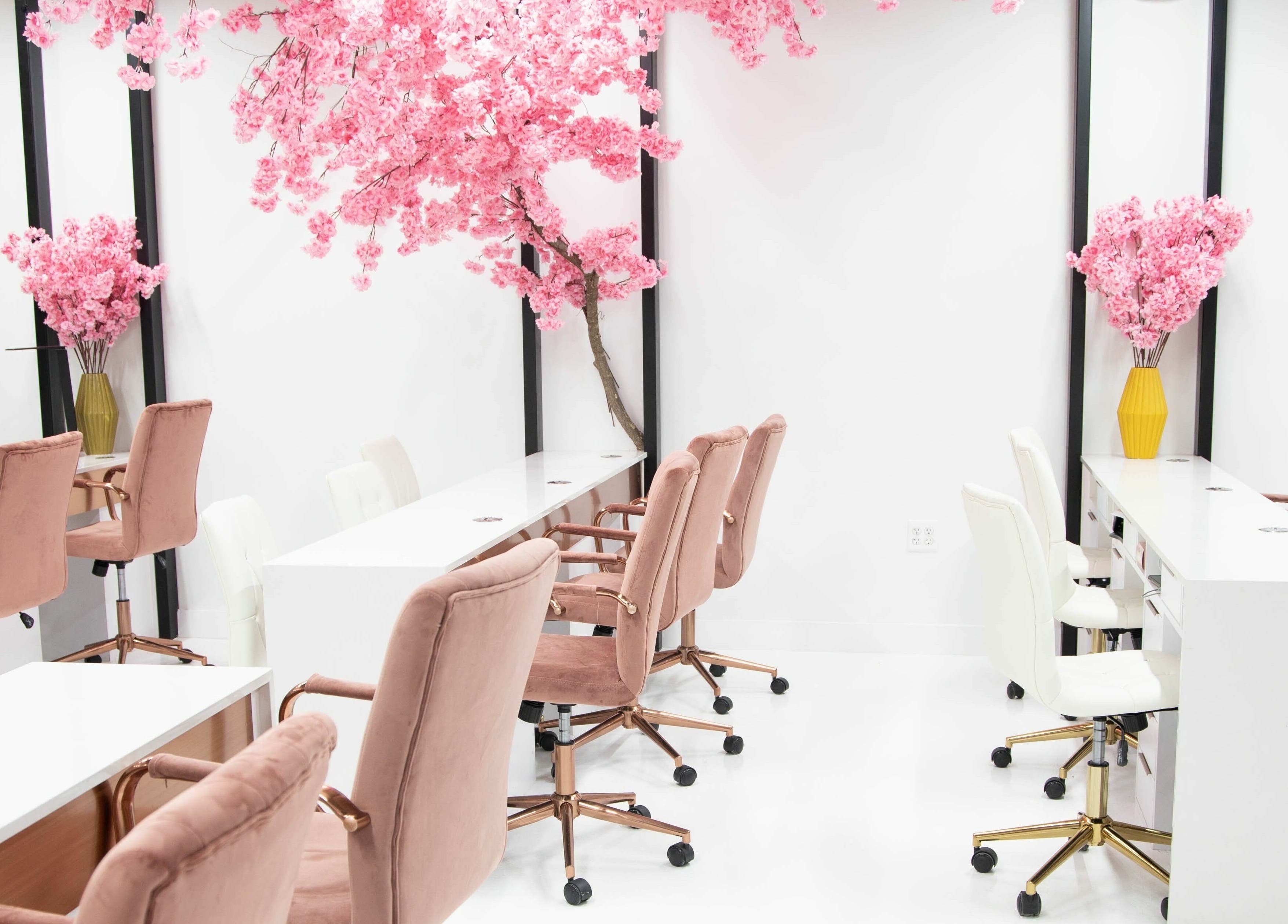 Elegant interior of Raizun Nail Spa in Fairfax, Virginia, US with pink chairs and cherry blossom decor.