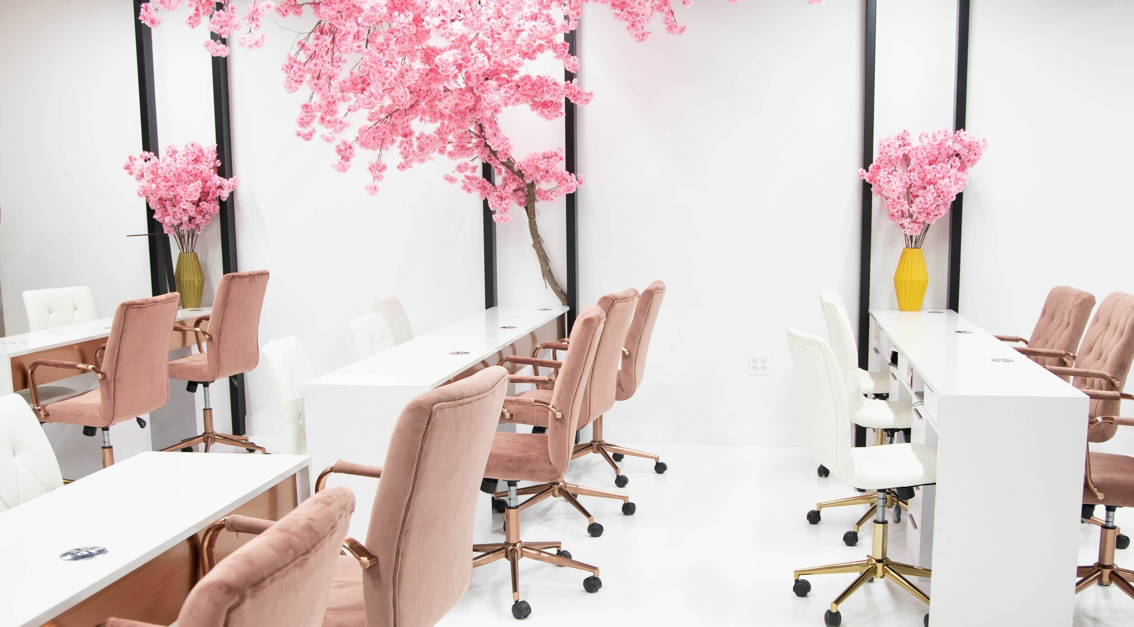 Elegant interior of Raizun Nail Spa in Fairfax, Virginia, US with pink chairs and cherry blossom decor.