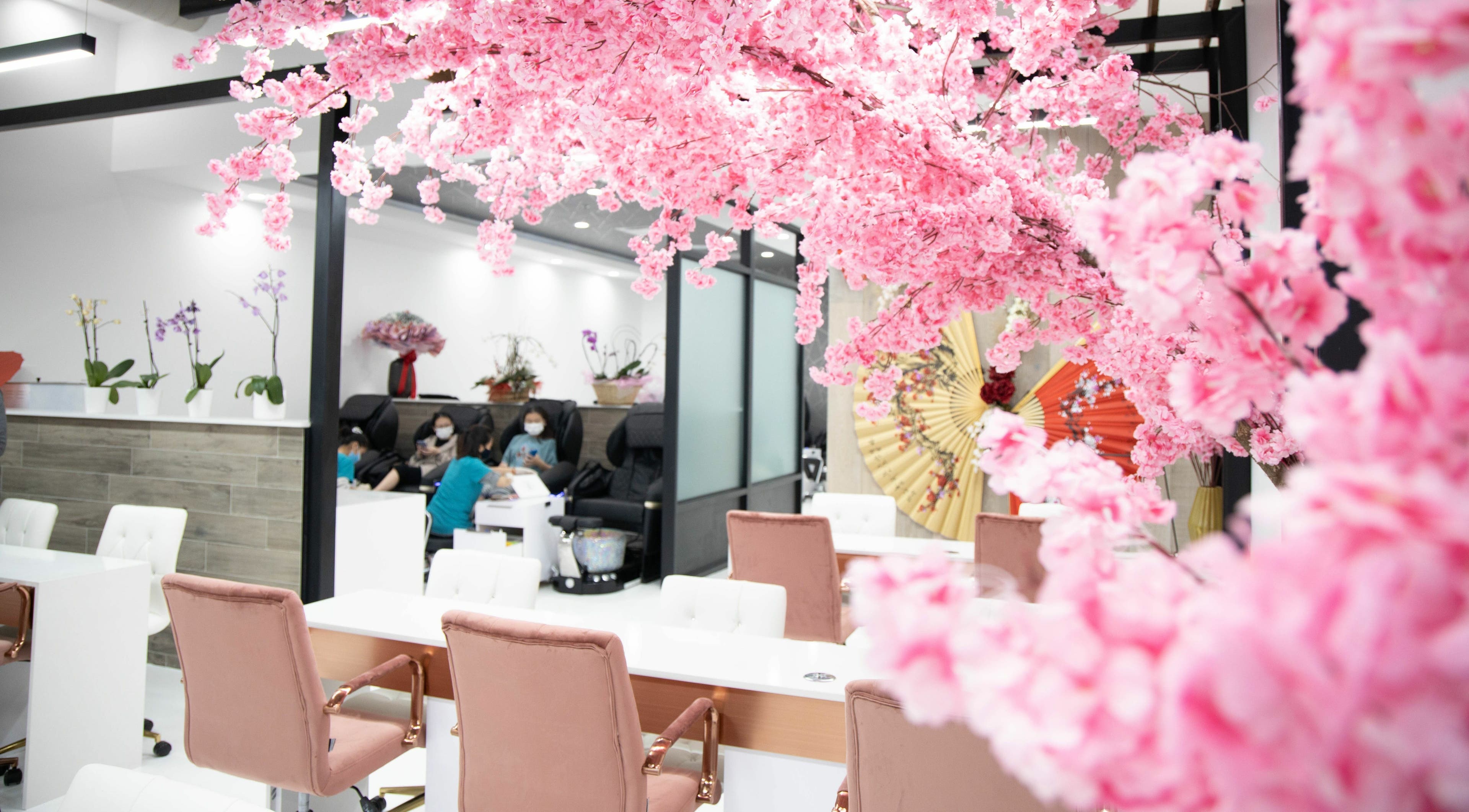 Lush cherry blossoms adorn Raizun Nail Spa in Fairfax, Virginia, US, offering a serene beauty experience.