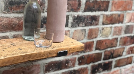Rustic shelf decor at Evergreen Salon Durham Road in Gateshead, England, GB with a glass, bottle, and vase.