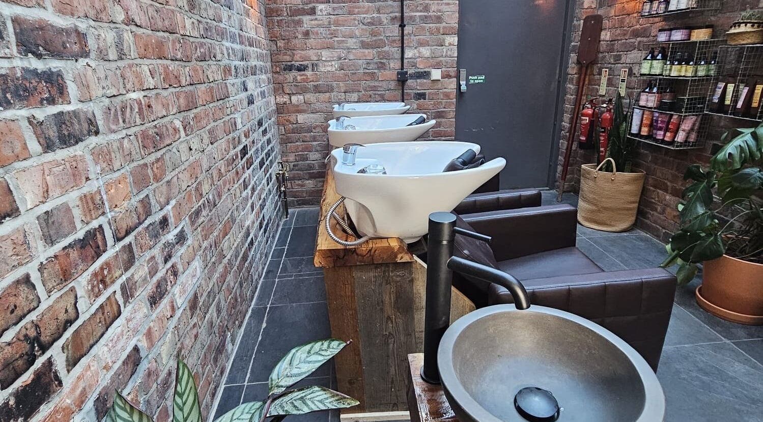 Chic wash stations at Evergreen Salon Durham Road, Gateshead, England, GB. Brick walls add rustic charm.
