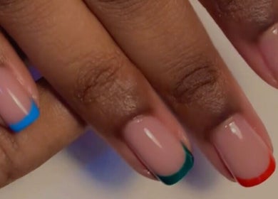 Colorful French manicure at Nails & Co., Lekki, Lagos, NG with vibrant nail tips in blue, green, red, and yellow.