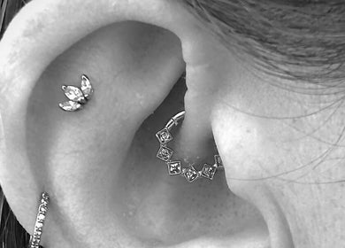 Close-up of stylish ear piercings at Inferno Fossa, Douglas, Middle, GB.