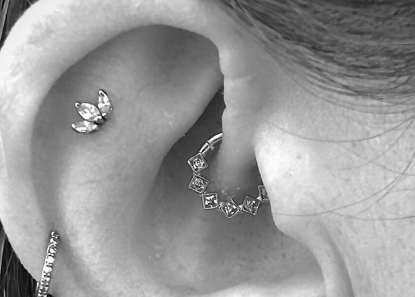 Close-up of stylish ear piercings at Inferno Fossa, Douglas, Middle, GB.