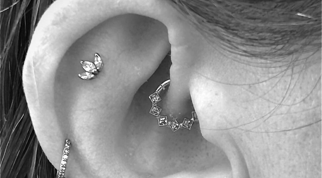 Close-up of stylish ear piercings at Inferno Fossa, Douglas, Middle, GB.