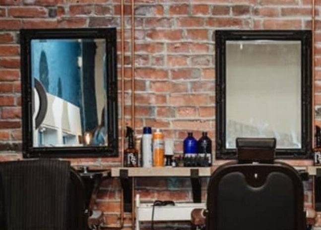 Cozy barber station at Prohibition Barber & Bourbon Room in Canmore, Alberta, CA with a brick wall backdrop.