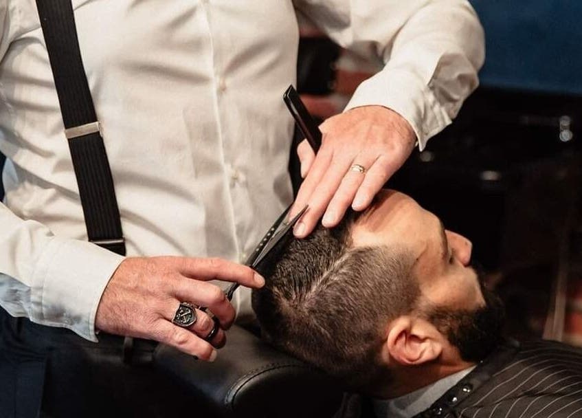 Barber styling hair at Prohibition Barber & Bourbon Room in Canmore, Alberta, CA.