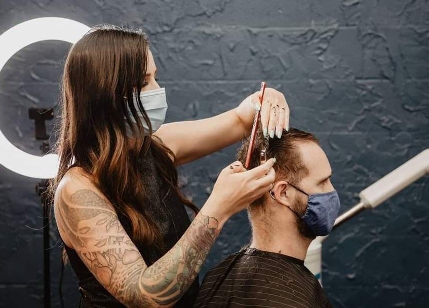 Hair stylist at Prohibition Barber & Bourbon Room, Canmore, Alberta, CA, providing a detailed haircut.