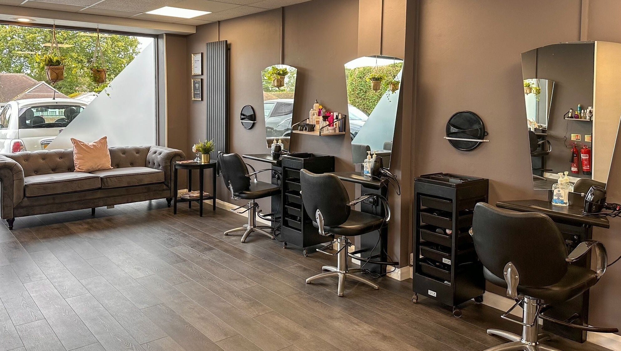Chic interior of Mane Street Salon LLP, East Grinstead, England, GB featuring stylish seating and workstations.