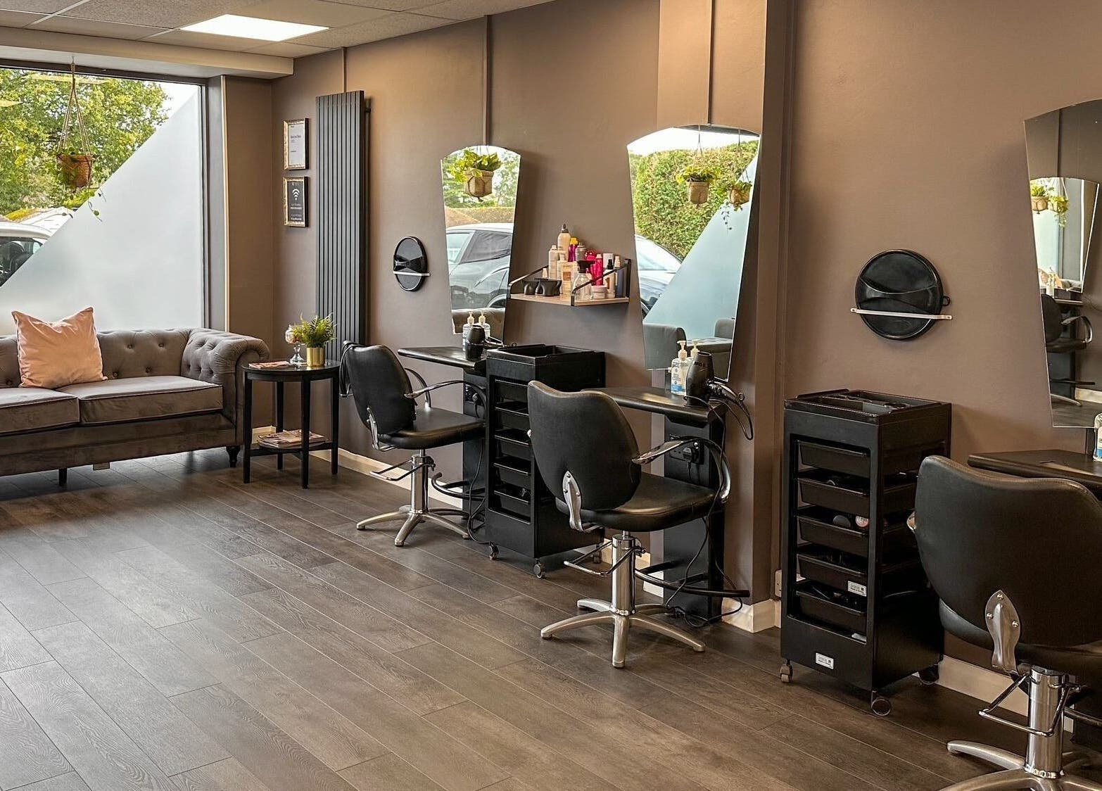 Chic interior of Mane Street Salon LLP, East Grinstead, England, GB featuring stylish seating and workstations.