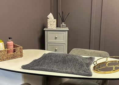 Cozy treatment nook at Mane Street Salon LLP, East Grinstead, England, GB, showcasing towels and skincare products.