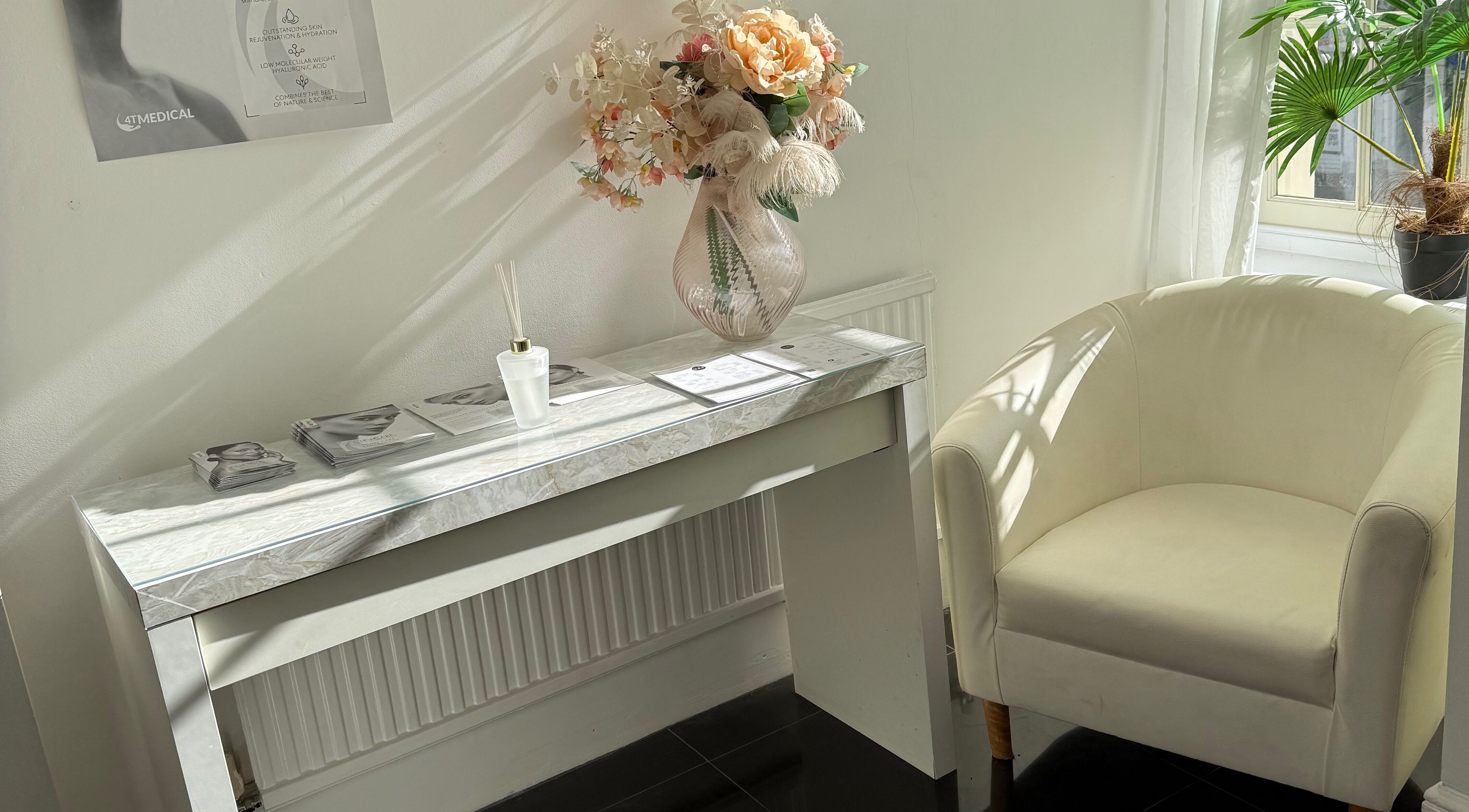 Elegant reception area at MBA Aesthetics & Training, Southampton, England, GB featuring a white chair and floral decor.
