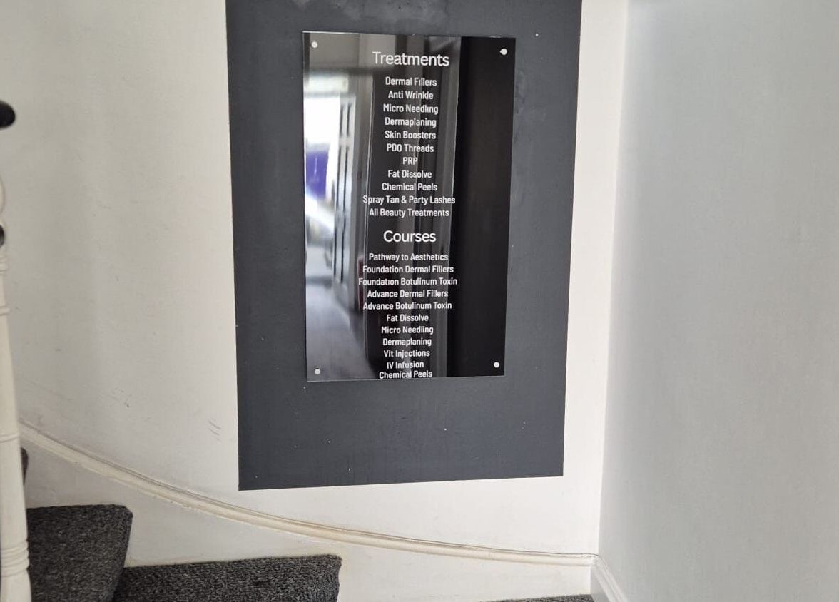 A sleek wall sign displaying treatments and courses at MBA Aesthetics & Training in Southampton, England, GB.