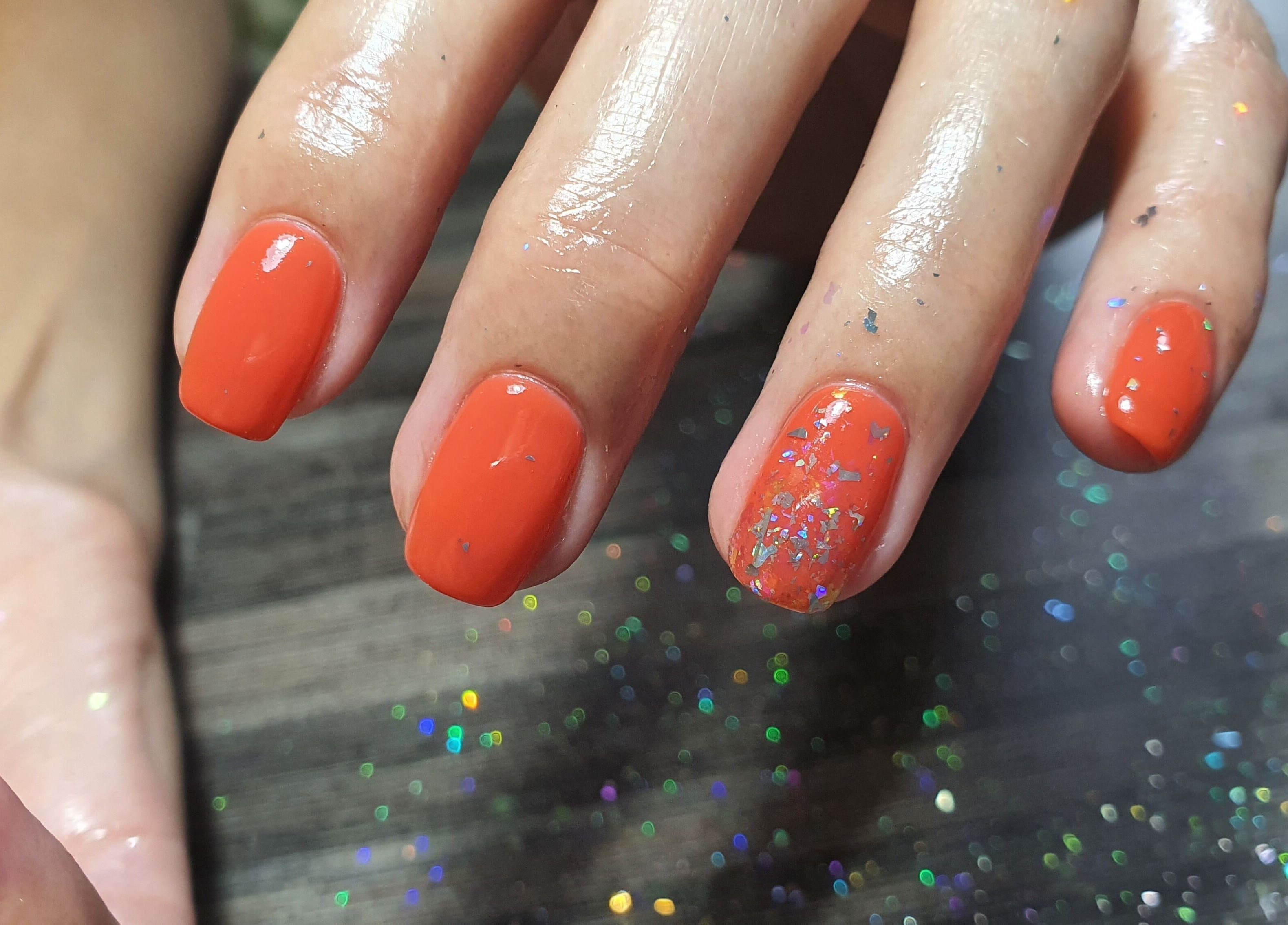 Vibrant orange nails with glitter at Get Nailed Beauty Salon at Eclipse, Bloemfontein, Free State, ZA.