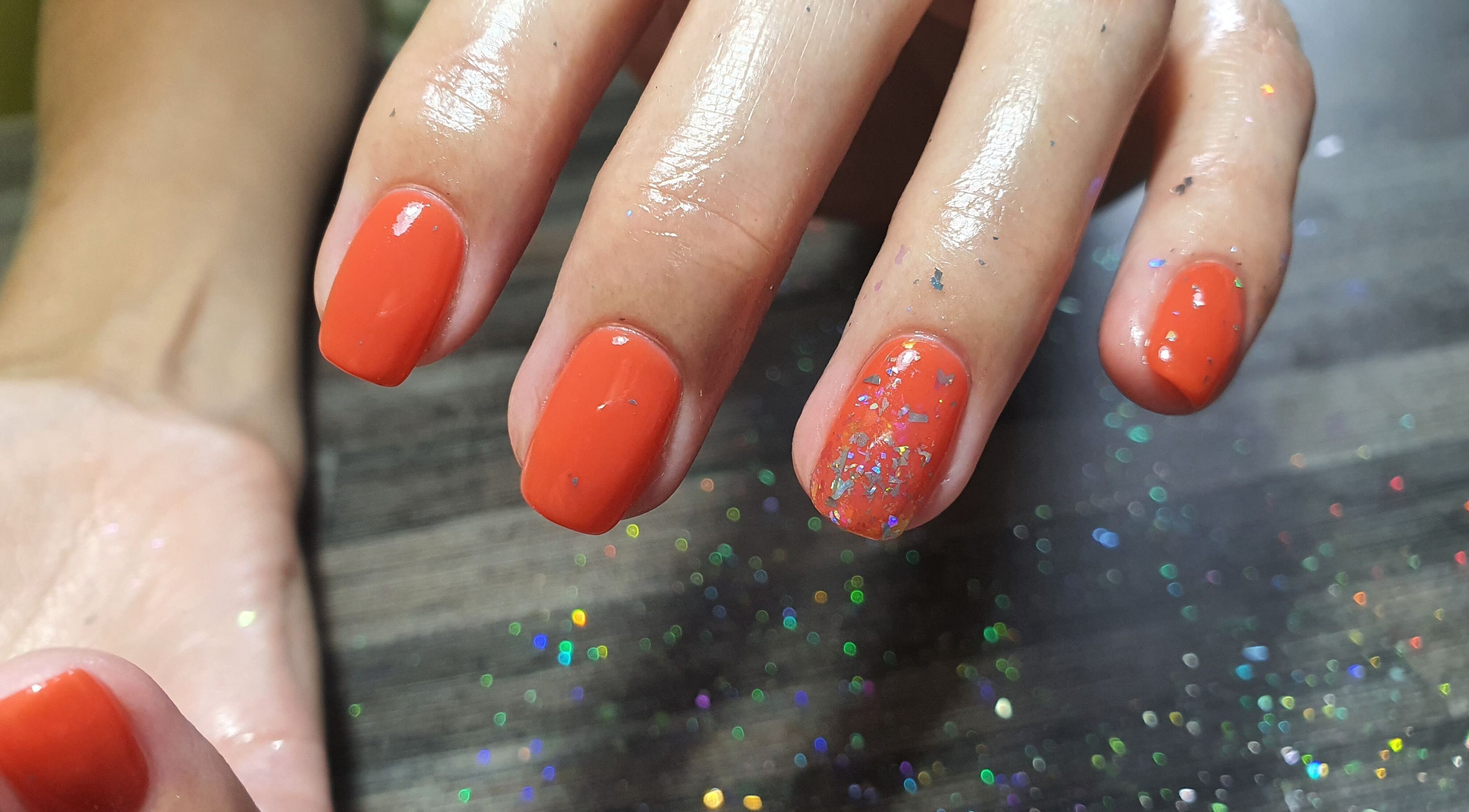 Vibrant orange nails with glitter at Get Nailed Beauty Salon at Eclipse, Bloemfontein, Free State, ZA.