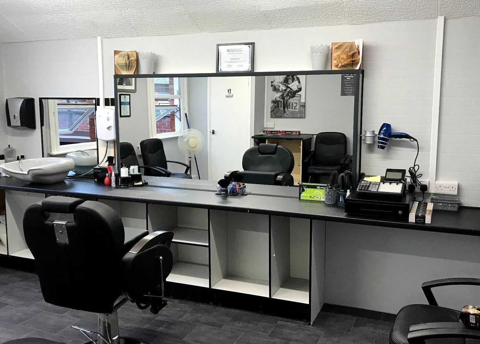 Contemporary barber chairs and stations at 3 Of A Kind Barbers in Malvern, England, GB offering stylish grooming.