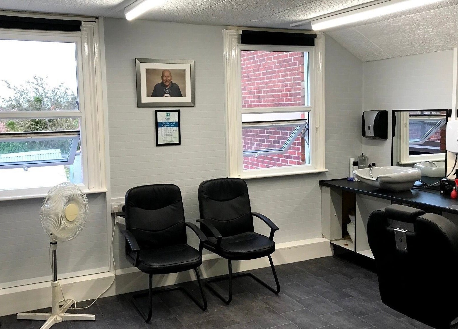 Interior of 3 Of A Kind Barbers in Malvern, England, GB with chairs, mirrors, and clean decor.