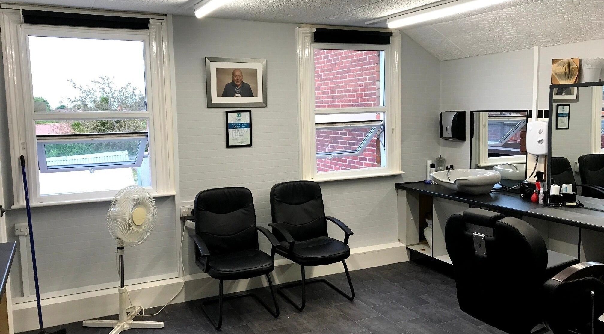 Interior of 3 Of A Kind Barbers in Malvern, England, GB with chairs, mirrors, and clean decor.