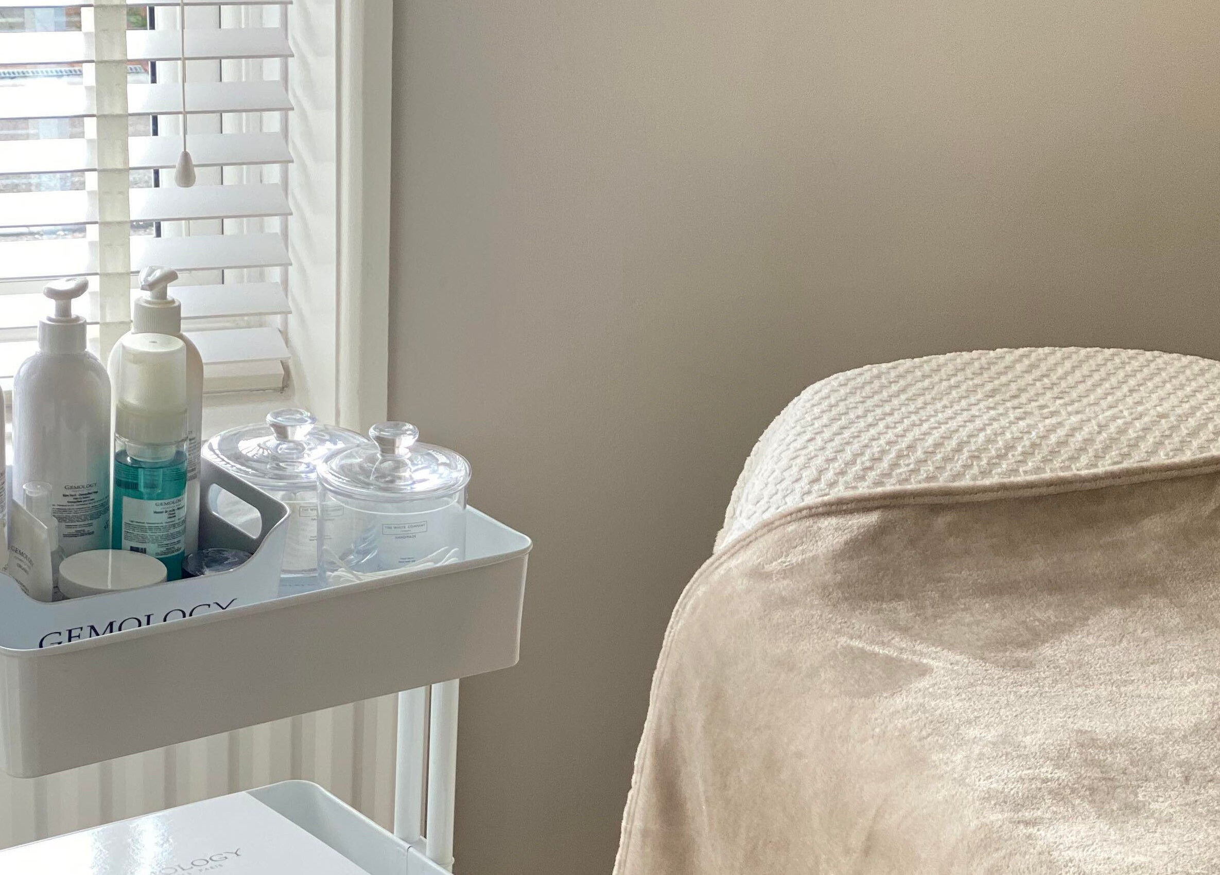 Relaxing treatment bed and product cart at Victoria Mac Skin, Carshalton, England, GB offering serene wellness.