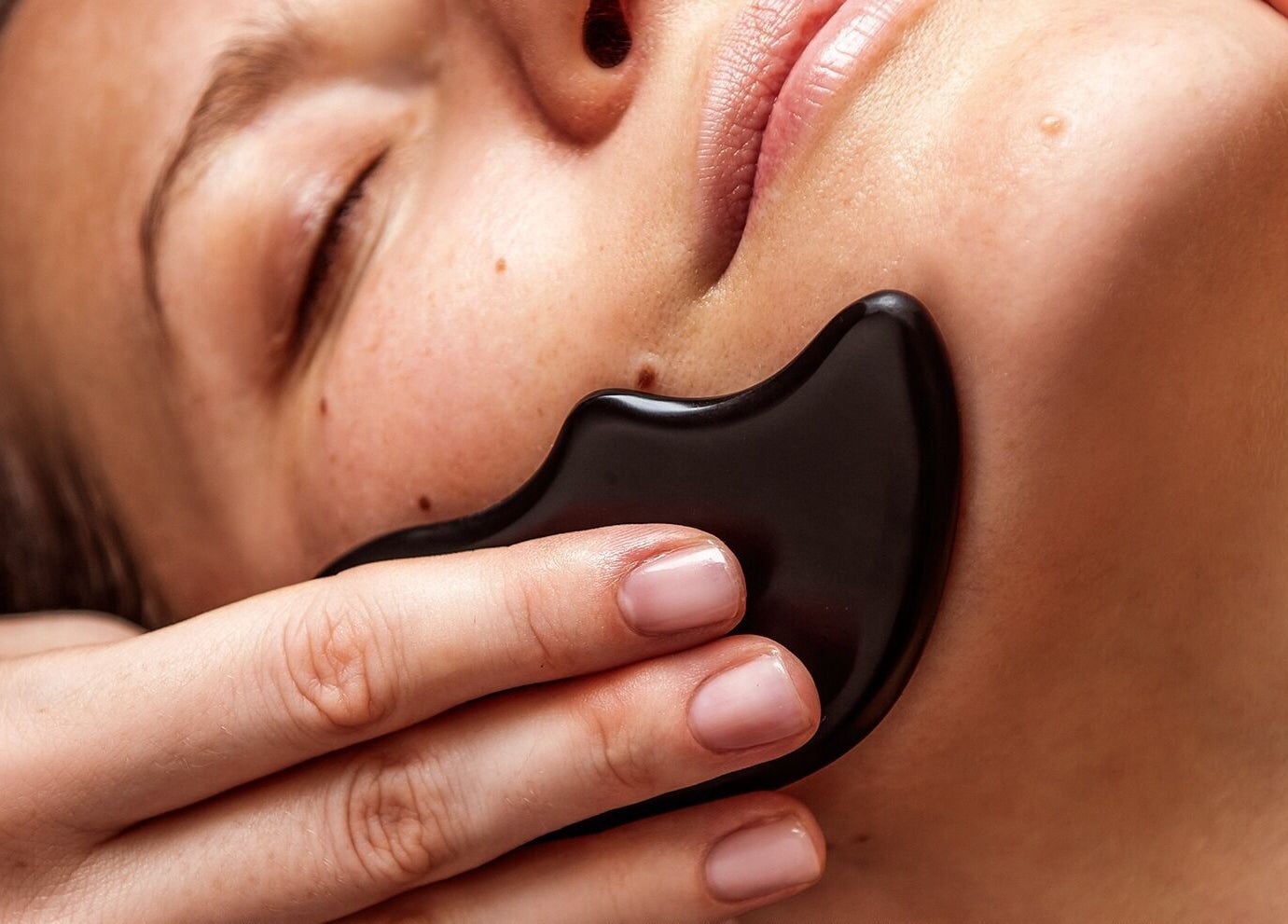 Facial gua sha treatment at Victoria Mac Skin in Carshalton, England, GB. Enhances skin radiance and relaxation.