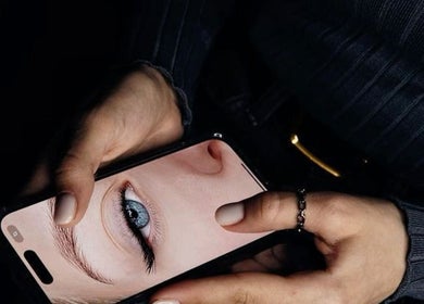 Closeup of a phone displaying an eye, highlighting beauty treatments at Lashcore | Rondebosch East, Cape Town.