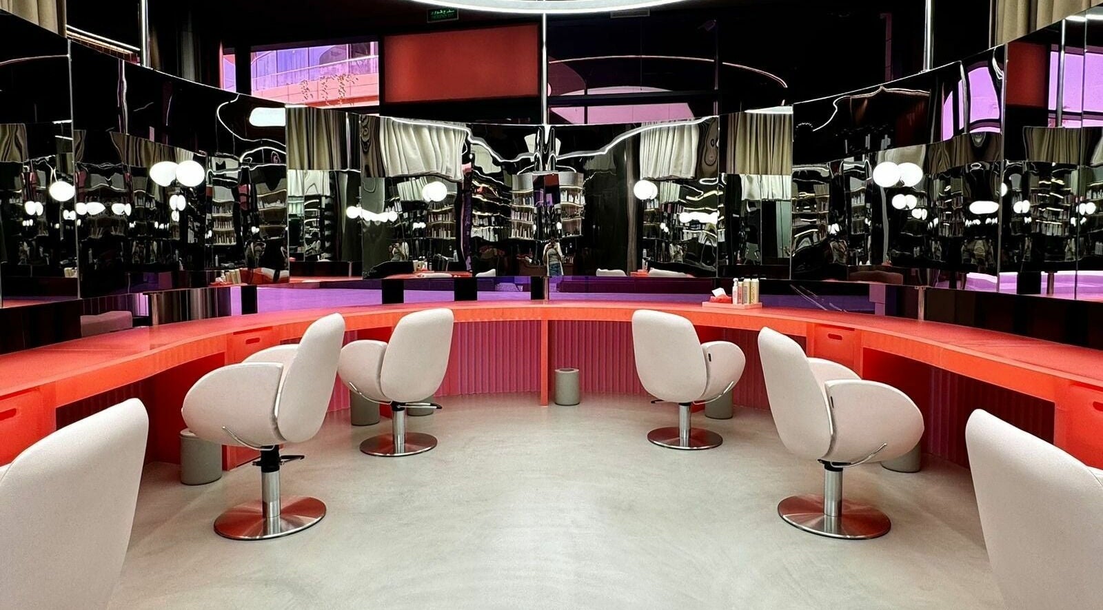 Stylish salon interior at Base & Boon - Diplomatic Quarter, Riyadh, SA with modern chairs and sleek mirrors.