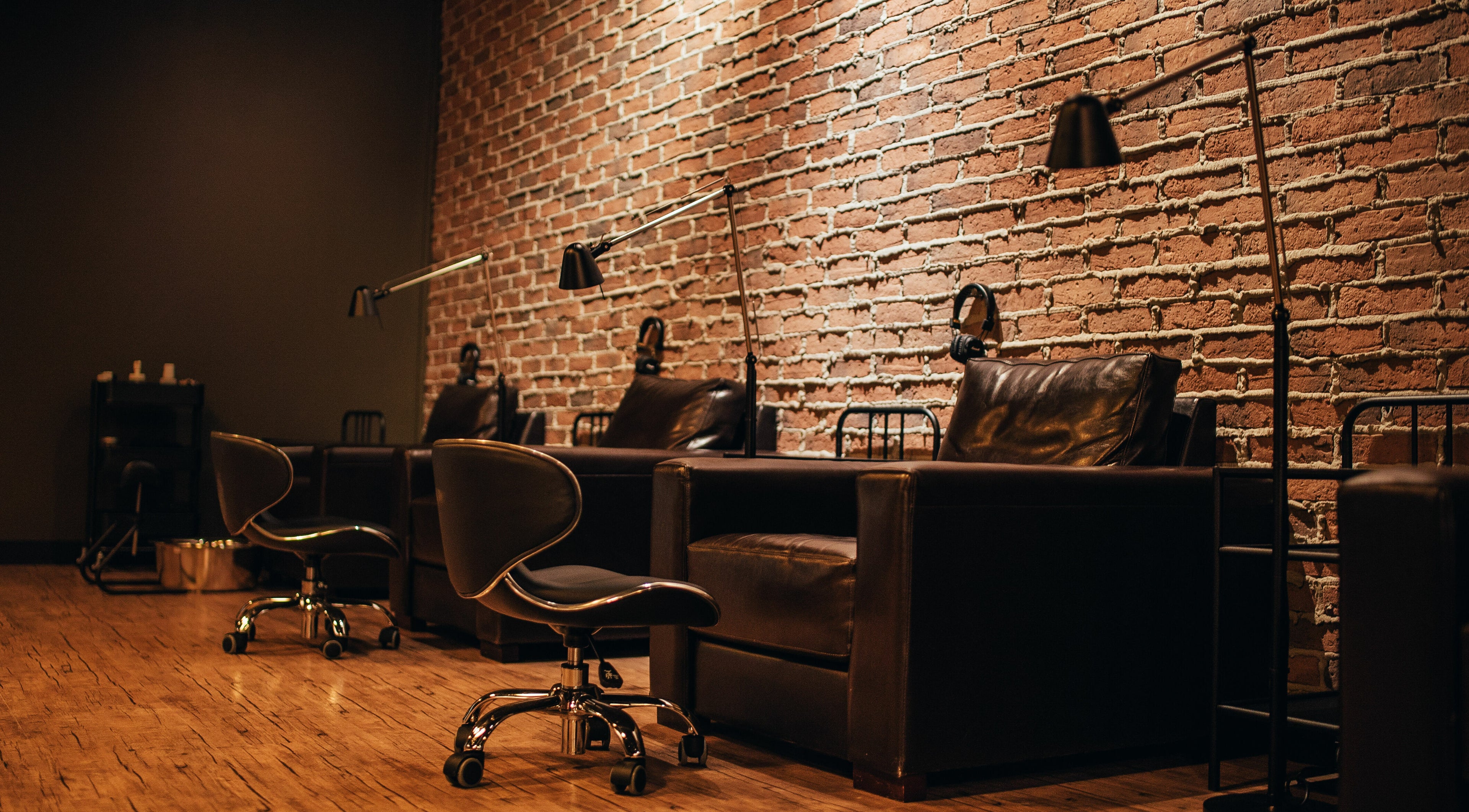 Cozy seating with brown leather chairs in Blacksmith Parlour, Winnipeg, Manitoba, CA, accentuated by brick walls.