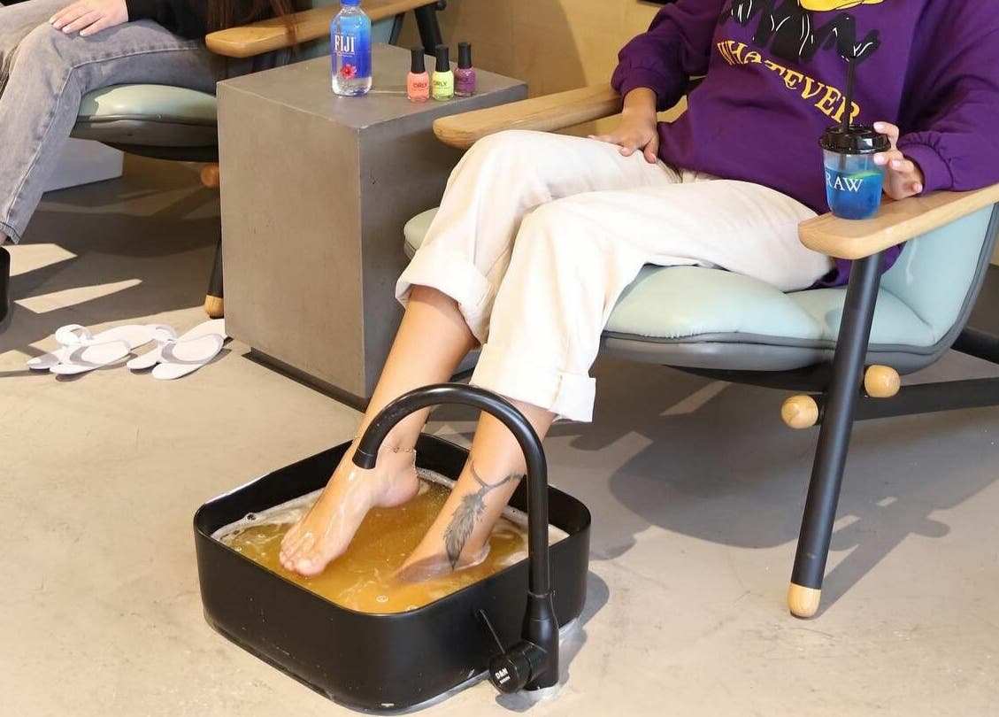 Clients enjoying footbath pampering at Raw Beauty Salon, Abu Dhabi, AE. Relaxing wellness experience.