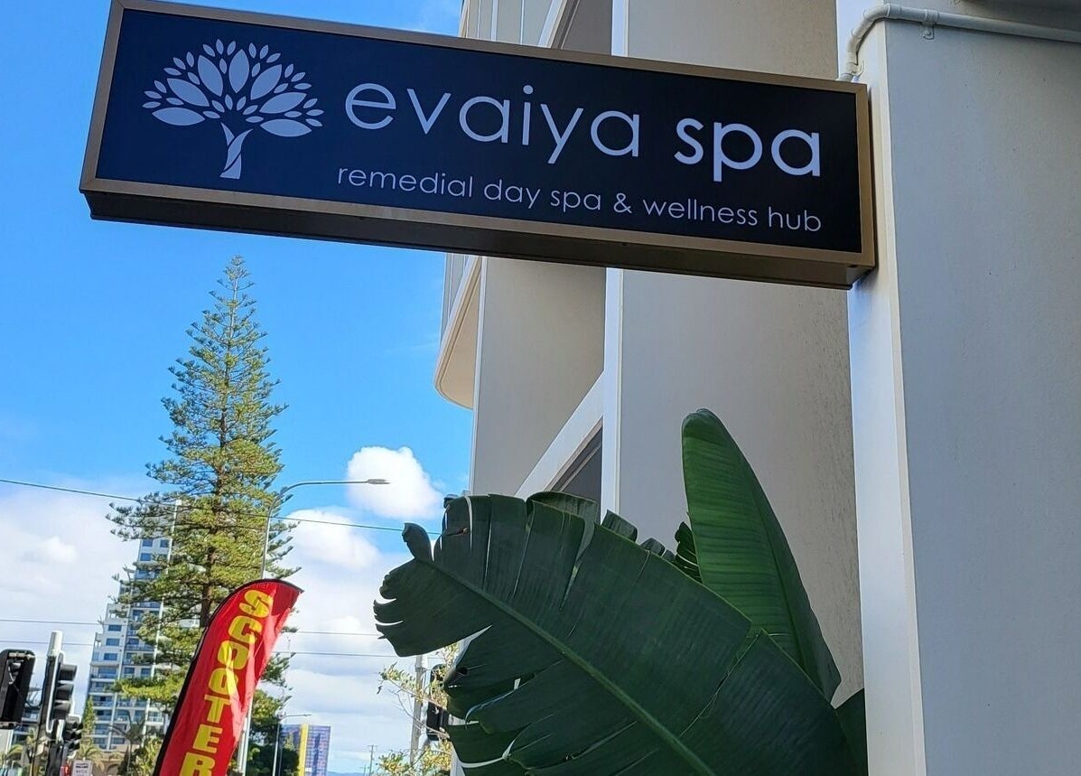 Evaiya Spa sign at Surfers Paradise, Queensland, AU, amidst a bright blue sky and urban backdrop.