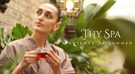 Woman enjoying tea in lush garden at Thy Spa Bath, England, GB, embodying relaxation and tranquility.
