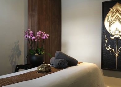 Relaxing massage room at Thy Spa Oxford, located in Oxford, England, GB, featuring orchids and elegant decor.