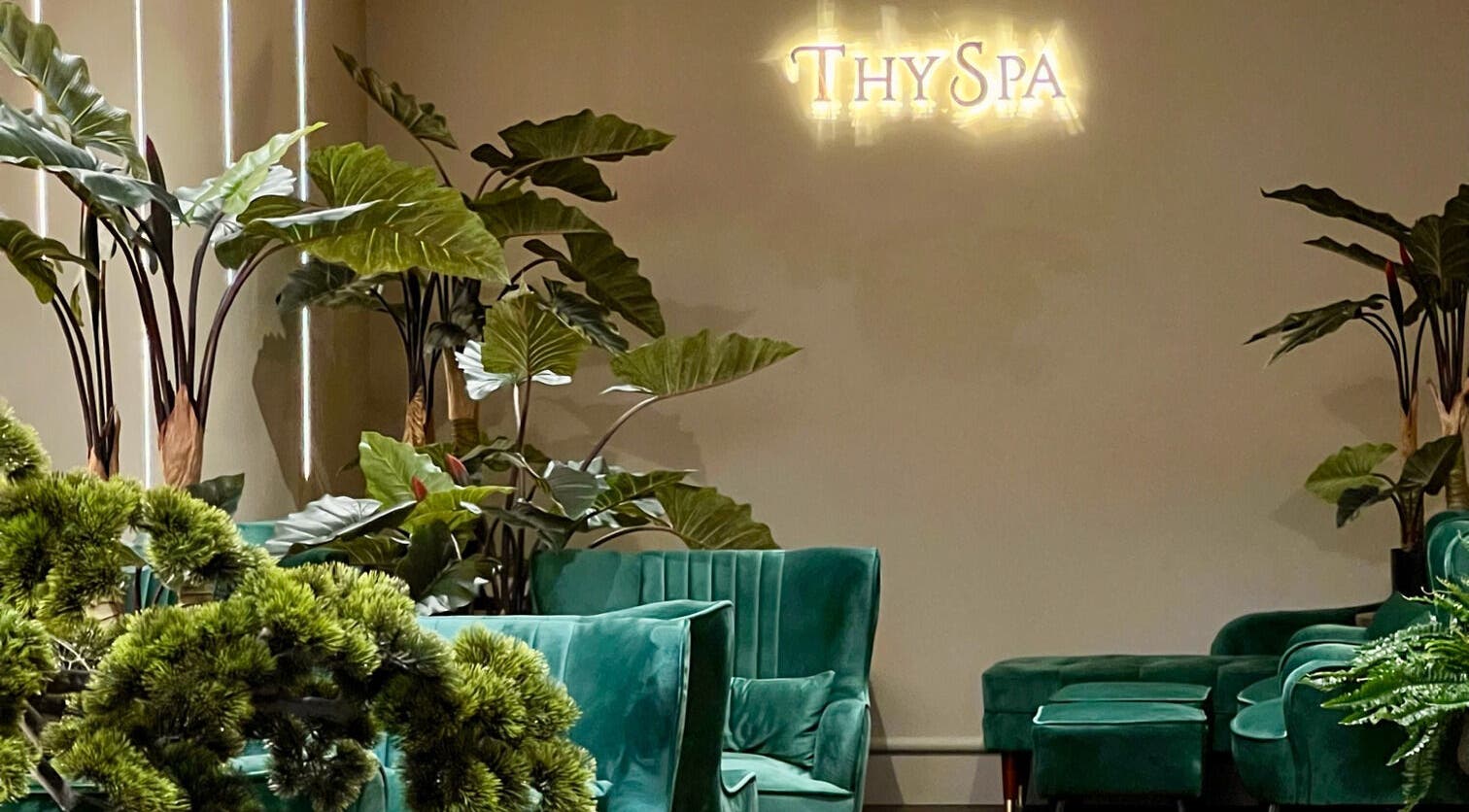 Relaxing lounge at Thy Spa Bath in Bath, England, GB with lush greenery and plush seating.
