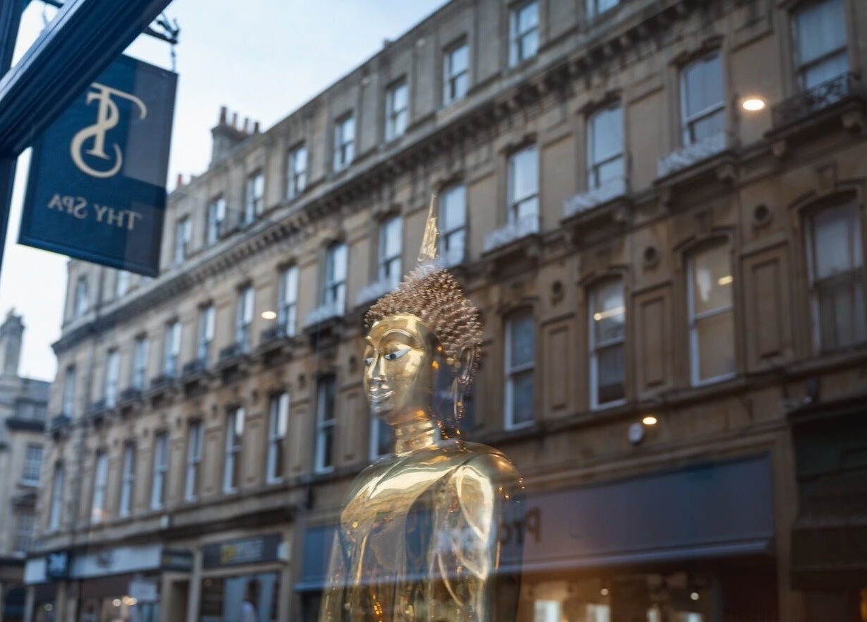 Golden Buddha statue at Thy Spa Bath, Bath, England, GB reflecting tranquility and elegance.