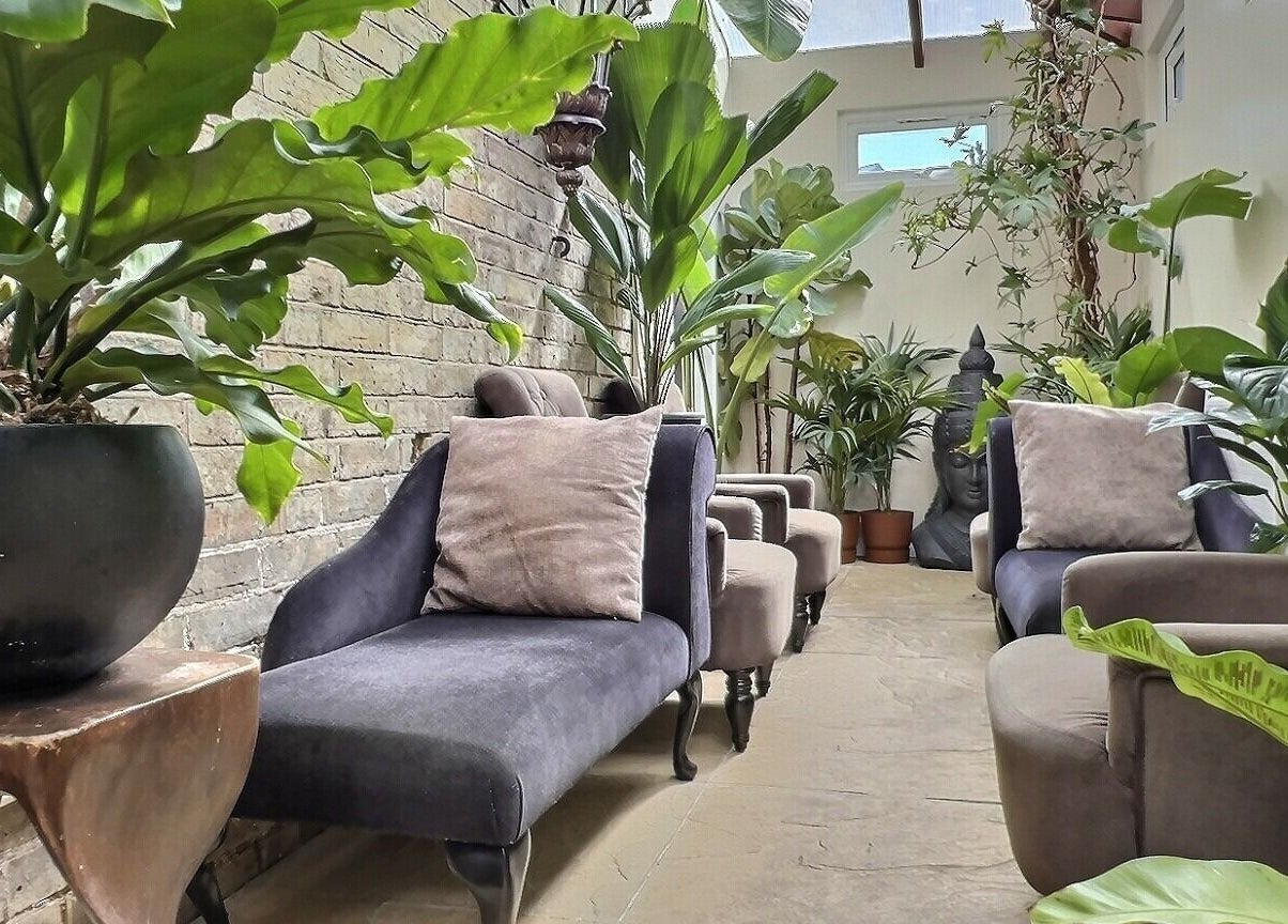 Relaxing lounge area at Thy Spa Oxford, featuring plush seating and lush plants in Oxford, England, GB.