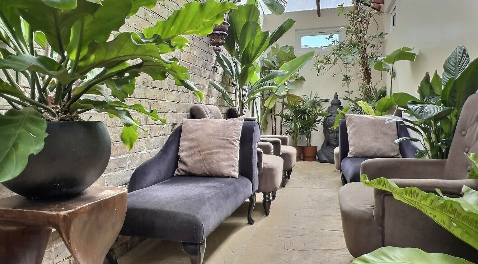 Relaxing lounge area at Thy Spa Oxford, featuring plush seating and lush plants in Oxford, England, GB.